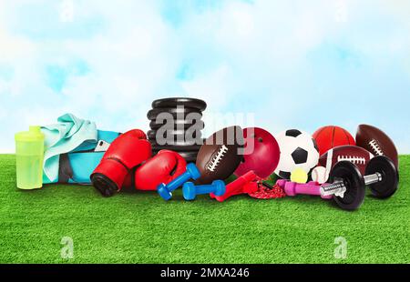 Set verschiedener Sportausrüstung auf grünem Gras Stockfoto