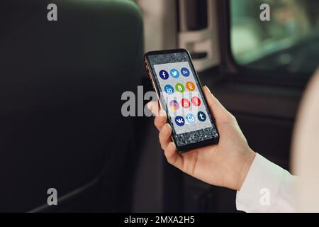 MYKOLAIV, UKRAINE - 30. APRIL 2020: Frau mit Telefon und Social-Media-Apps-Symbolen auf dem Bildschirm, Nahaufnahme Stockfoto