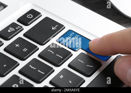 Frau drückt die Taste zur Qualitätskontrolle auf der Computertastatur, Nahaufnahme Stockfoto