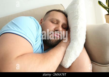 Fauler, übergewichtiger Mann, der zu Hause auf dem Sofa schläft Stockfoto