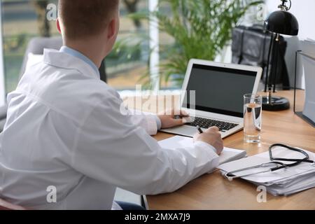 Professioneller Arzt, der am Laptop arbeitet, in der Praxis, Nahaufnahme Stockfoto