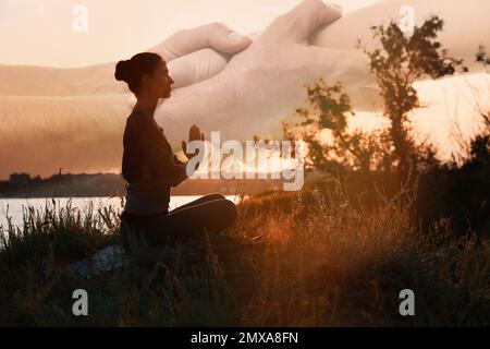 Doppelte Exposition von meditierenden Frauen und Händen, die sich bei Sonnenuntergang im Freien berühren. Yoga hilft im Alltag: Harmonie von Geist, Körper und Seele Stockfoto