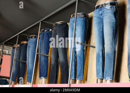 Verschiedene stilvolle Jeans auf Schaufensterpuppen im Geschäft Stockfoto