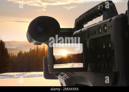 Wunderschöne Aussicht auf verschneiten Wald mit einer professionellen Videokamera aufnehmen Stockfoto