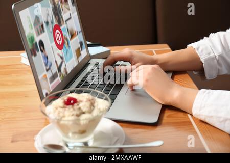 MYKOLAIV, UKRAINE - 4. MAI 2020: Frau nutzt Pinterest-Website auf einem Laptop in Innenräumen, Nahaufnahme. Social-Media-Web Stockfoto