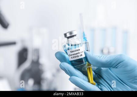 Arzt mit Coronavirus-Impfstoff und Spritze im Labor, Nahaufnahme Stockfoto