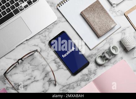 MYKOLAIV, UKRAINE - 30. APRIL 2020: Smartphone mit Facebook-App auf Tisch, flach liegend. Social-Media-Website Stockfoto