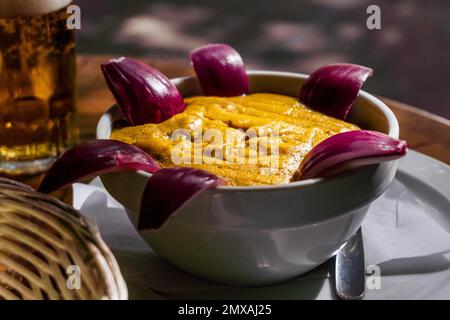 Köstliche traditionelle Speisen von Gran Canaria namens Gofio Escaldado werden mit rohen roten Zwiebeln gegessen Stockfoto