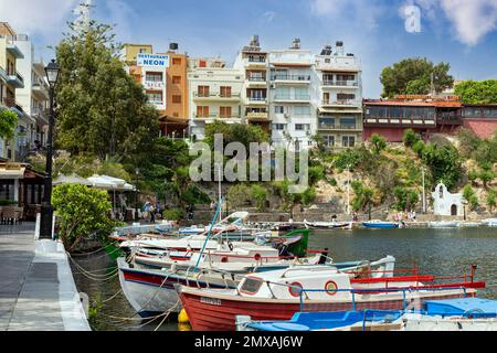 Kleine Fischerboote vor Anker in einer Bucht in der Stadt Agios Nikolaos, Kreta, Griechenland Stockfoto