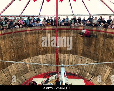 Zuschauer blicken auf Motorradfahrer auf eine steile Holzwand, Pitt's Todeswand, Attraktion, Schauspieler beim Oktoberfest, München, Bayern, Deutschland Stockfoto