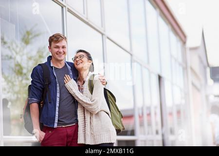 Manchmal brauchen wir alle nur ein gutes Lachen. Ein junges Paar auf dem Campus. Stockfoto