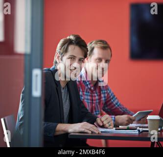 Zwei der Besten in der Branche. Porträt von zwei Kollegen, die an einem Tisch in einem Sitzungssaal sitzen. Stockfoto