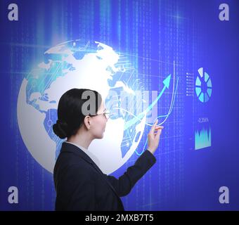 Junge Frau, die einen virtuellen Bildschirm mit Weltkugel und Charts benutzt. Finanzhandelskonzept Stockfoto