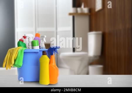 Verschiedene Reinigungsmittel auf grauem Steintisch im Badezimmer, Platz für Text Stockfoto