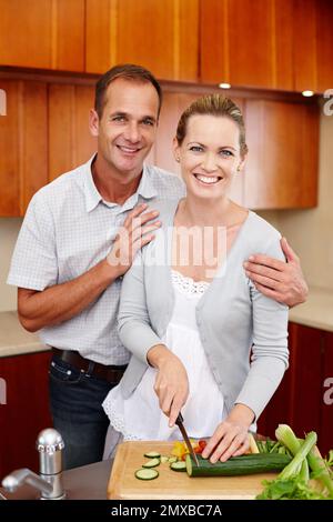 Honig im... Ich habe Hunger. Ein Porträt eines glücklichen Paares, das in seiner Küche steht und kocht. Stockfoto