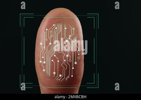 Mann mit biometrischem Fingerabdruck-Scanner auf dunklem Hintergrund, Nahaufnahme Stockfoto