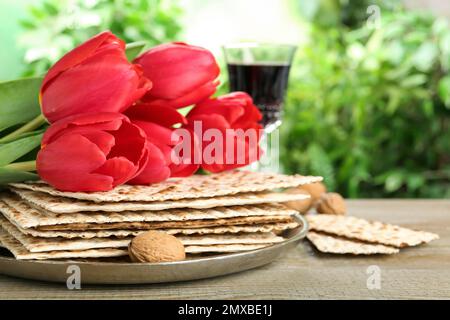 Traditionelle Matzos und Tulpen auf Holztisch. Pesach (Passover)-Feier Stockfoto