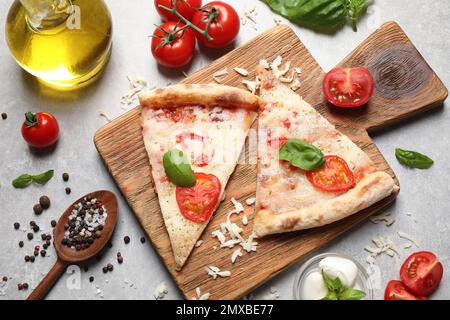 Scheiben leckerer Pizza Margherita auf hellgrauem Tisch, flach liegend Stockfoto