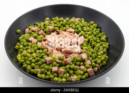 Thunfisch mit Erbsen und Stückchen gekochten Schinken, isoliert auf weißem Hintergrund Stockfoto