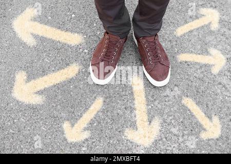 Ein Mann, der auf der Straße neben Pfeilen steht, Nahaufnahme Stockfoto