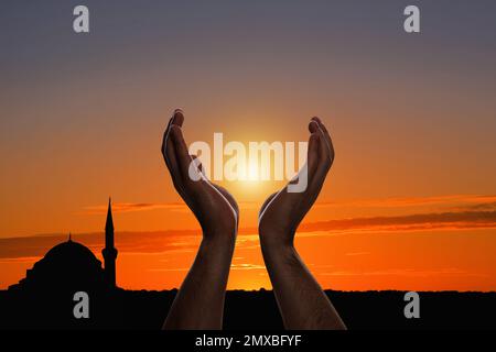 Muslimischer Mann betet draußen bei Sonnenuntergang, dicht gemacht Stockfoto