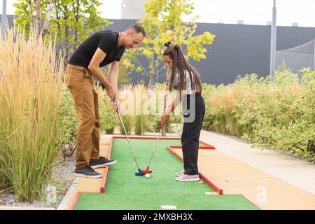 Vater und Tochter spielen Mini Golf Stockfoto