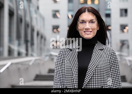 Gesichtserkennungssystem. Reife Frau mit digitalem biometrischem Raster, im Freien Stockfoto