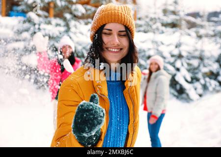 Eine Gruppe von Freunden, die draußen Schneebälle spielen. Winterurlaub Stockfoto