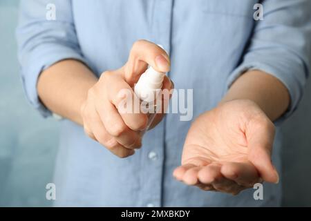 Frau, die Antiseptikum auf die Hand spritzt, Nahaufnahme. Virenschutz Stockfoto