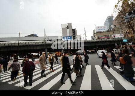 Fußgänger, die die Straße überqueren in Shimbashi, Tokio, Japan. Stockfoto