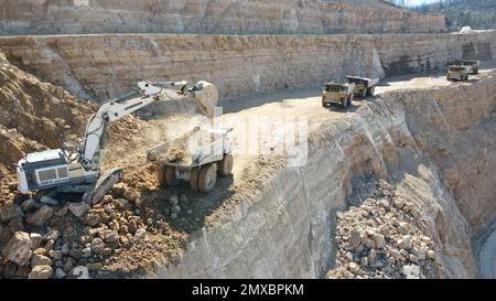 Bagger beladen Dämpfer. Sie arbeiten auf einer riesigen Baustelle. Stockfoto