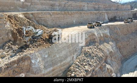 Bagger beladen Dämpfer. Sie arbeiten auf einer riesigen Baustelle. Stockfoto