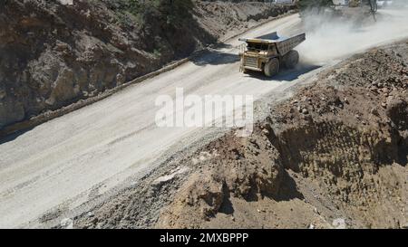 Großer Steinbruch-Müllwagen voller Steine. Ich transportiere das Erz in den Zerkleinerer. Bergbaumaschinen, die das Material für die Produktion transportieren. Stockfoto