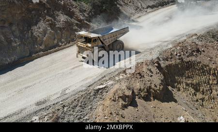 Großer Steinbruch-Müllwagen voller Steine. Ich transportiere das Erz in den Zerkleinerer. Bergbaumaschinen, die das Material für die Produktion transportieren. Stockfoto