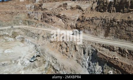 Großer Steinbruch-Müllwagen voller Steine. Ich transportiere das Erz in den Zerkleinerer. Bergbaumaschinen, die das Material für die Produktion transportieren. Stockfoto