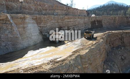 Großer Steinbruch-Müllwagen voller Steine. Ich transportiere das Erz in den Zerkleinerer. Bergbaumaschinen, die das Material für die Produktion transportieren. Stockfoto