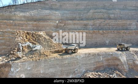 Bagger beladen Dämpfer. Sie arbeiten auf einer riesigen Baustelle. Stockfoto