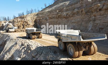 Bagger beladen Dämpfer. Sie arbeiten auf einer riesigen Baustelle. Stockfoto