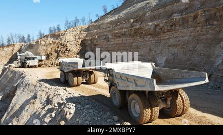 Bagger beladen Dämpfer. Sie arbeiten auf einer riesigen Baustelle. Stockfoto