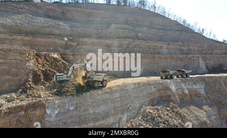 Bagger beladen Dämpfer. Sie arbeiten auf einer riesigen Baustelle. Stockfoto