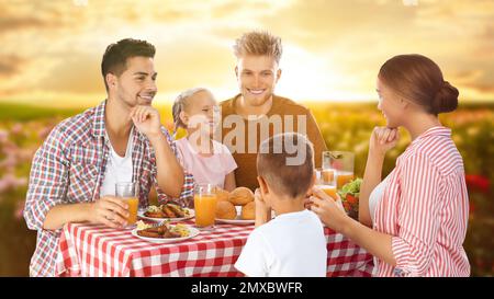 Glückliche Familie beim Picknick am Tisch im Garten Stockfoto