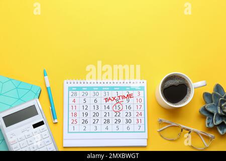 Kalender mit Worten „TAX TIME“ und Tasse Kaffee auf gelbem Hintergrund, flach liegend. Platz für Text Stockfoto