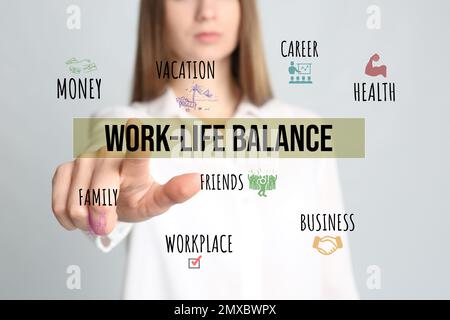 Eine Frau, die auf die Ausdrucksweise Work-Life-Balance vor hellem Hintergrund zeigt, Nahaufnahme Stockfoto