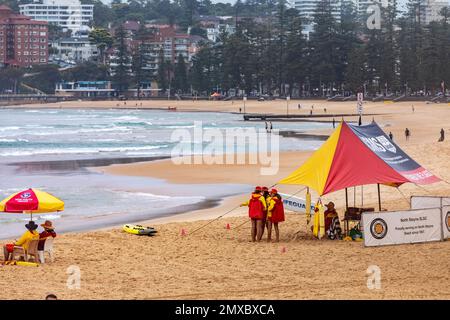 Australisches Surferrettungspersonal und schattiges Regenzelt am North Steyne Beach Manly Sydney, bewölkter, feuchter Sommertag, wie Surferretter beobachten Stockfoto