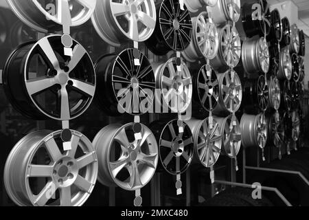 Leichtmetallfelgen auf einem Regal im Autoladen. Schwarzweiß-Effekt Stockfoto