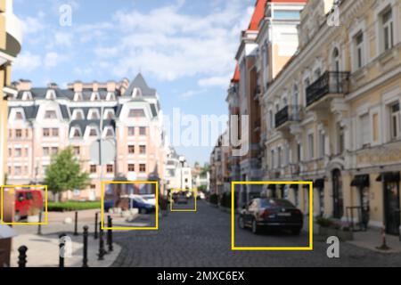 Verschwommener Blick auf Gebäude und Straße mit Scannerrahmen auf Autos in der Stadt. Maschinelles Lernen Stockfoto