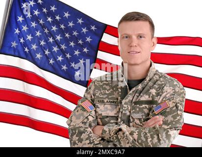 Männlicher Soldat und amerikanische Flagge auf weißem Hintergrund. Militärdienst Stockfoto