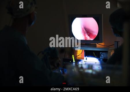 Professionelle Ärzte schauen auf medizinische Überwachung während der Operation im Operationssaal Stockfoto