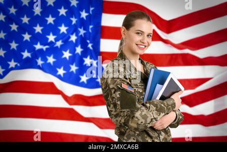 Soldatin mit Büchern und amerikanischer Flagge im Hintergrund. Militärdienst Stockfoto