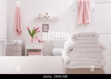 Ein Stapel frischer Handtücher auf einem hellgrauen Tisch im Badezimmer. Platz für Text Stockfoto